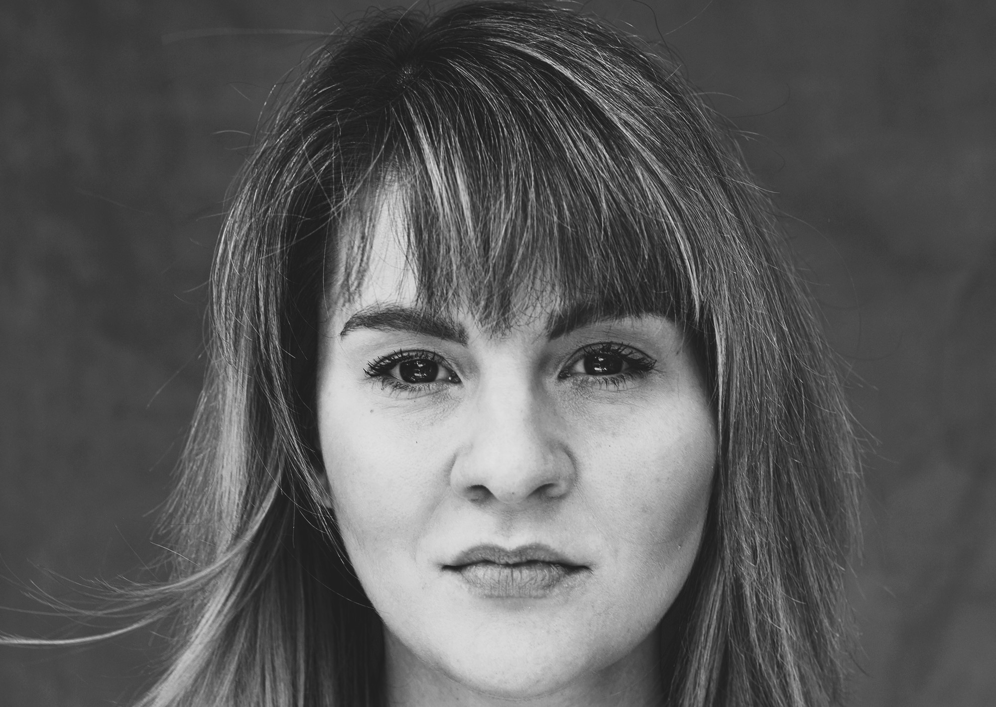 Ruth Madeley headshot, brown haired with blonde highlights staring directly into the camera.