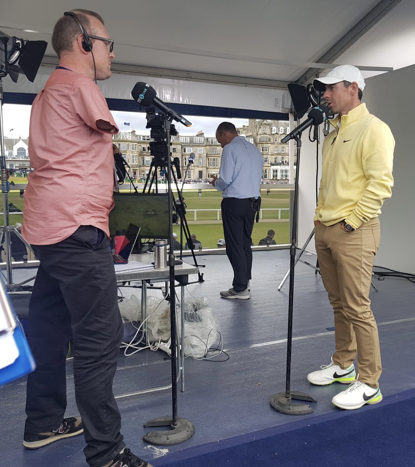 Andy standing on the left hand side of the photo interviewing Rory McIlroy on the right with the 1st tee and 18th green of St Andrews in the background