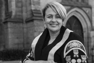 An image of Baroness Tanni Grey Thompson, she is wearing robes and is pictured in front of a church building.