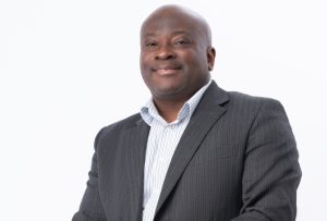 Black man in a suit sitting in a wheelchair.