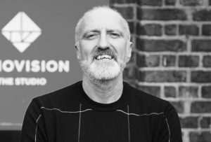 an image of a man smiling man with a beard wearing a dark shirt